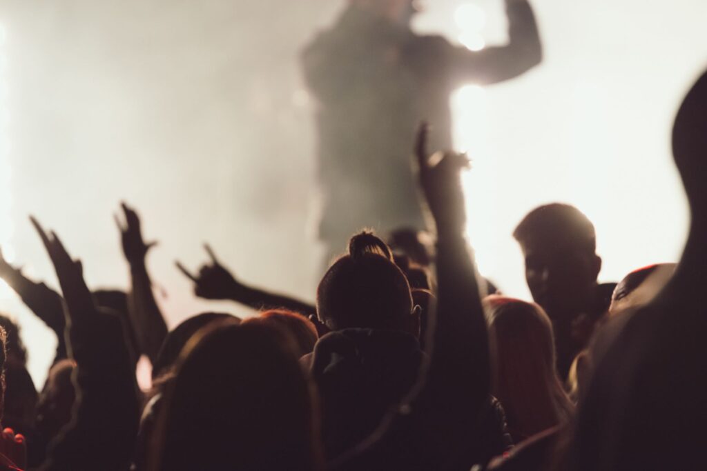 Dancing concert while singer is performing surrounded by lights