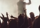 Dancing concert while singer is performing surrounded by lights