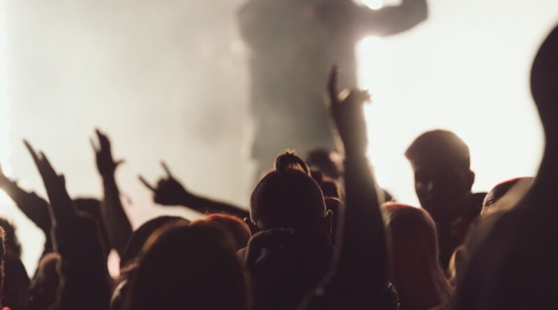 Dancing concert while singer is performing surrounded by lights